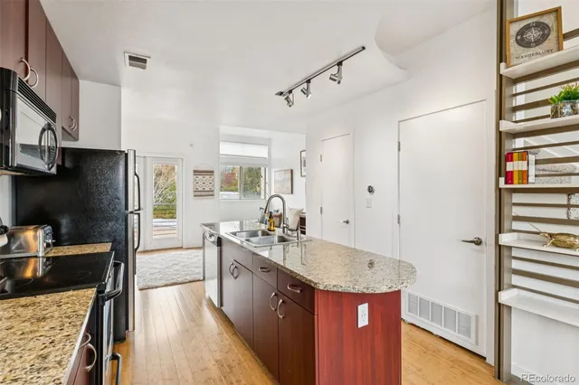 a kitchen with stainless steel appliances granite countertop a sink stove and refrigerator