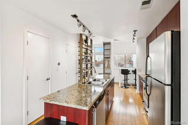 a kitchen with stainless steel appliances granite countertop a refrigerator and a sink