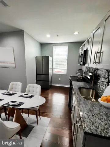 a kitchen with stainless steel appliances granite countertop a sink a stove and a refrigerator