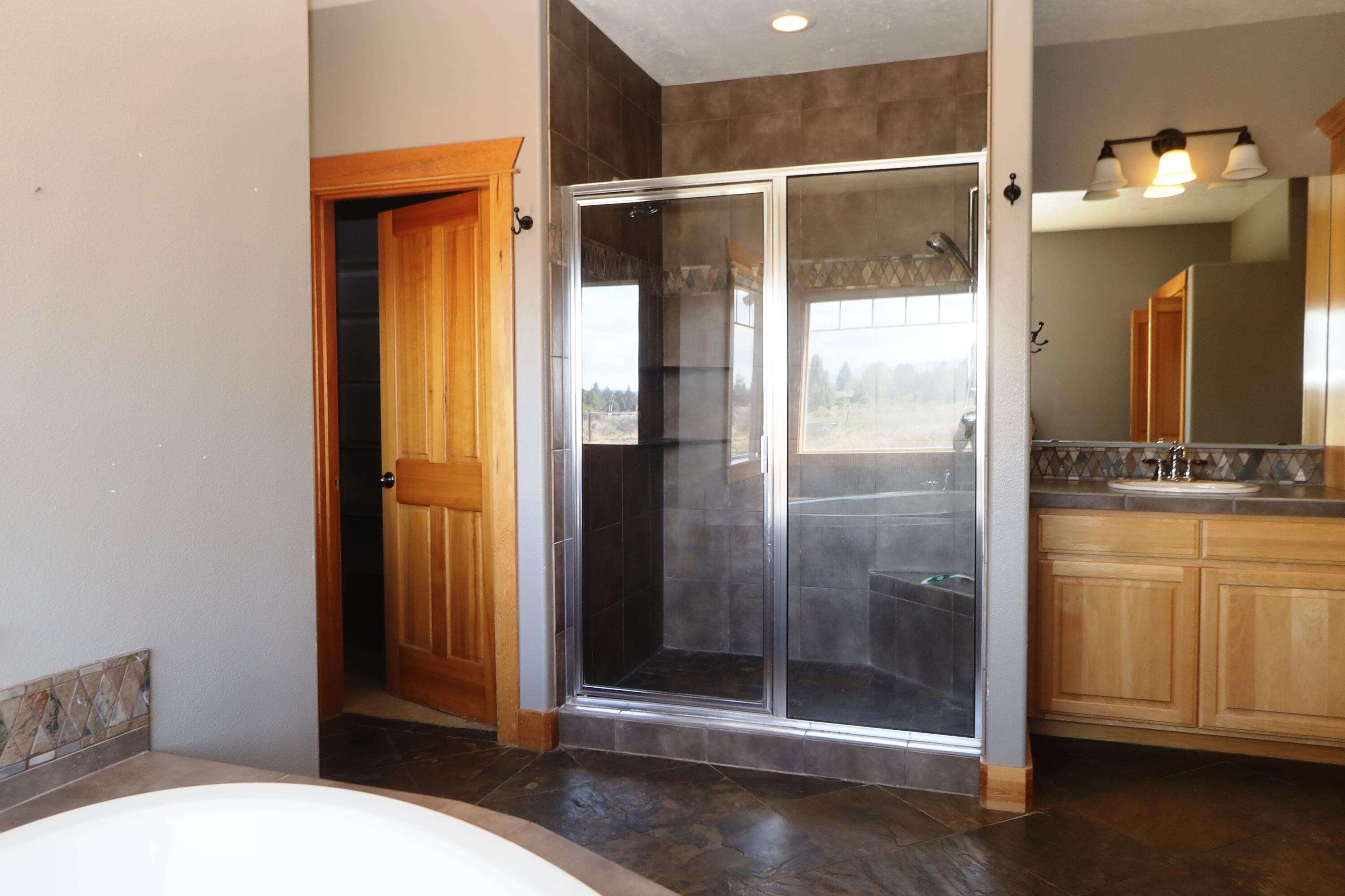 21491 Bear Creek Road Bend, OR 97701 - Photo 20 of 45 a bathroom with a shower and toilet