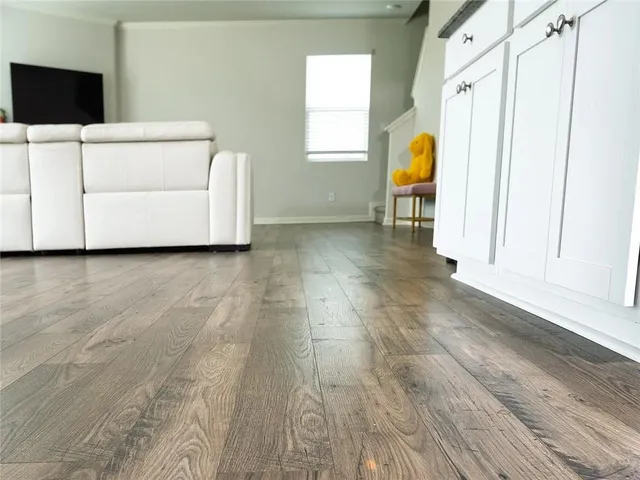 a view of a bedroom with wooden floor and furniture