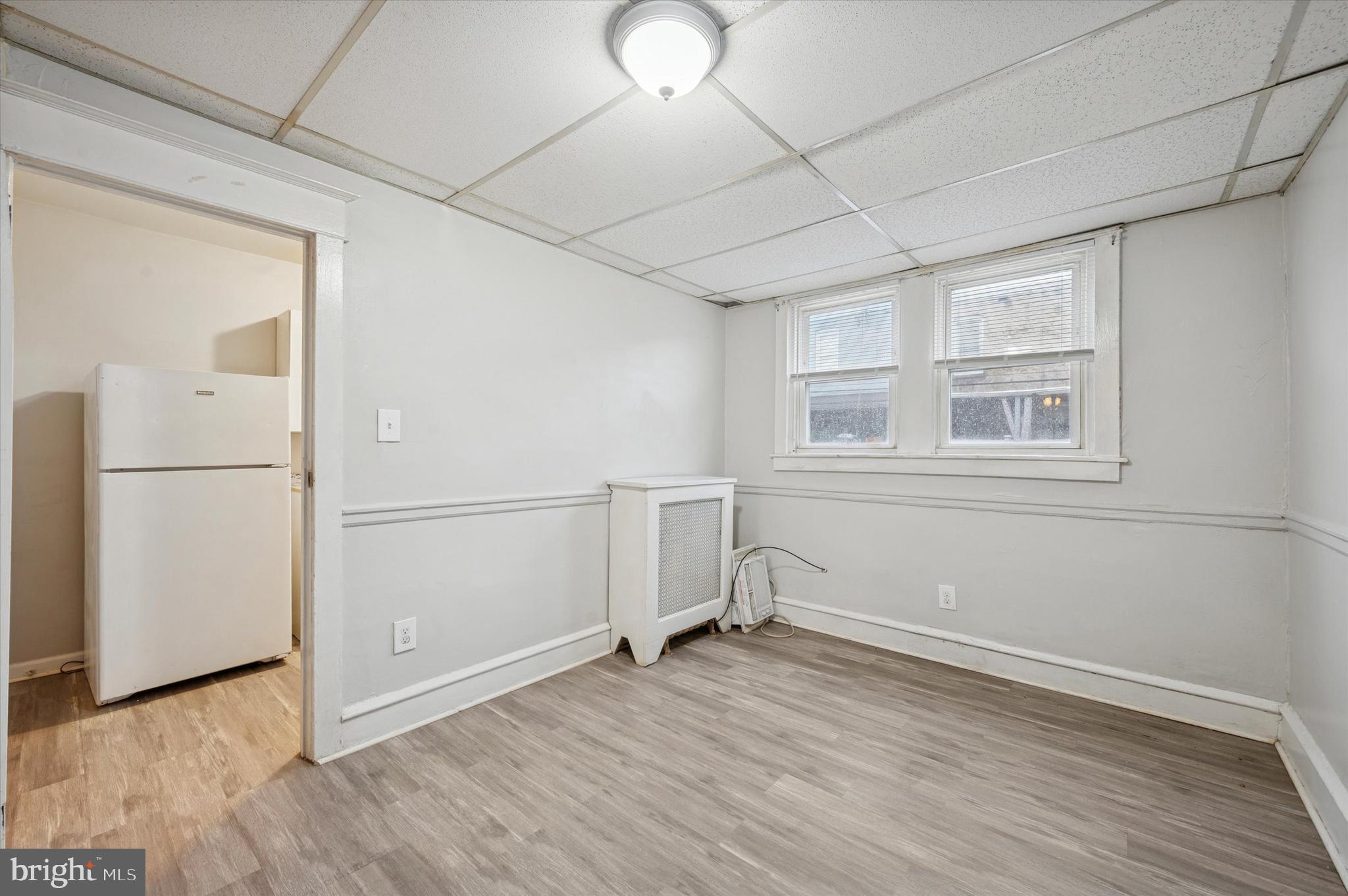 6619 Guyer Avenue, Unit 1 Philadelphia, PA 19142 - Photo 7 of 16 an empty room with wooden floor and windows