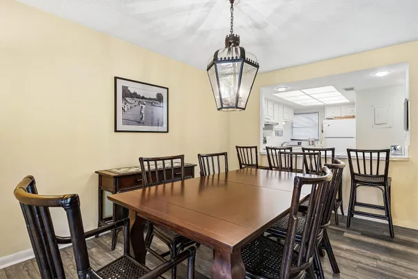 a view of a dining room with furniture a chandelier and wooden floor