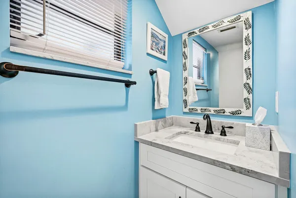 a bathroom with a granite countertop sink and a mirror