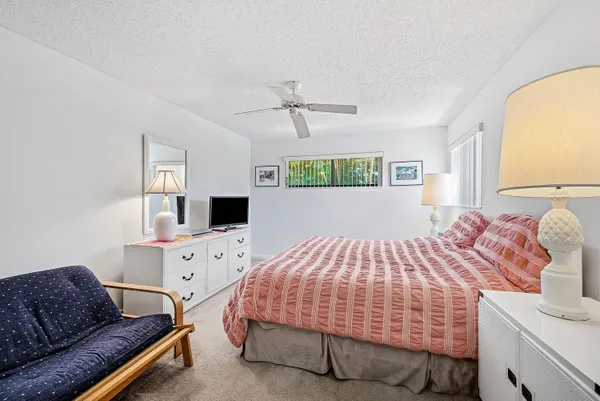 a bedroom with a bed and a flat tv screen on the dresser