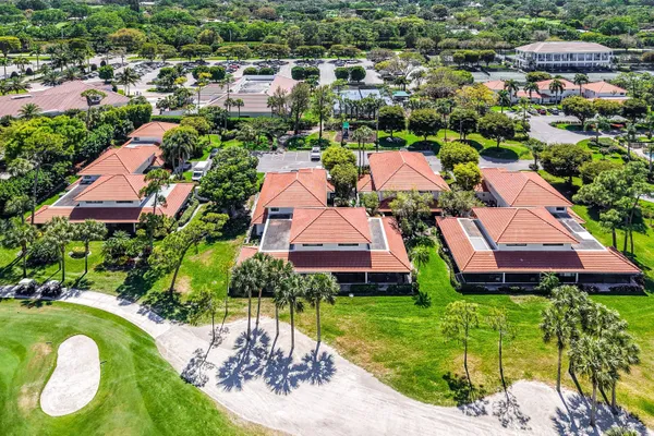 an aerial view of a house with a garden and lake view