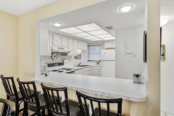 a kitchen with kitchen island a stove a table and chairs