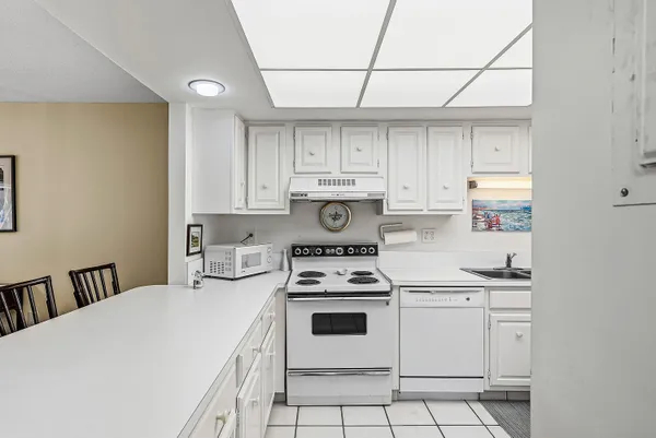 a kitchen with white cabinets and white appliances