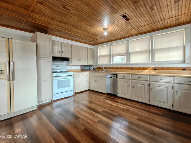 a kitchen with stainless steel appliances granite countertop a stove sink and cabinets