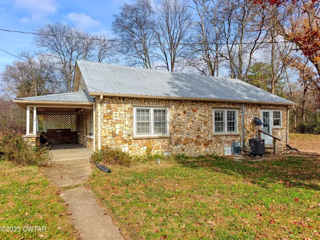 a view of a house with backyard sitting area and garden