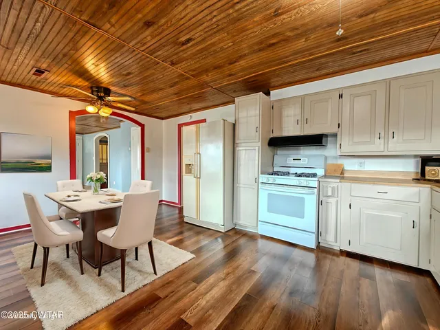 a kitchen with cabinets wooden floor a sink and stainless steel appliances