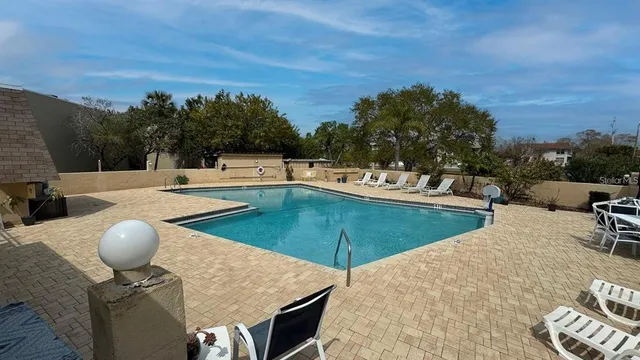 a roof deck with table and chairs and potted plants