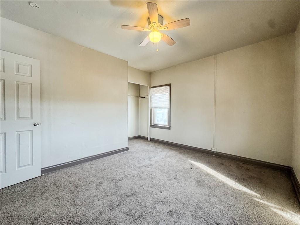 119 Heim Avenue Butler, PA 16001 - Photo 7 of 10 an empty room with a chandelier fan and windows