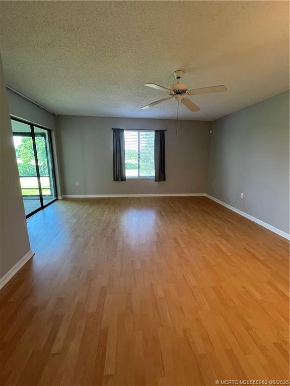 5335 Southeast Miles Grant Road, Unit 214 Stuart, FL 34997 - Photo 16 of 17 an empty room with wooden floor and windows