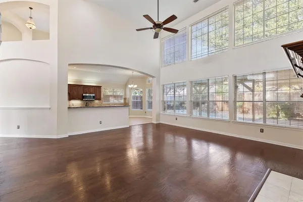 a view of an empty room with a window and wooden floor