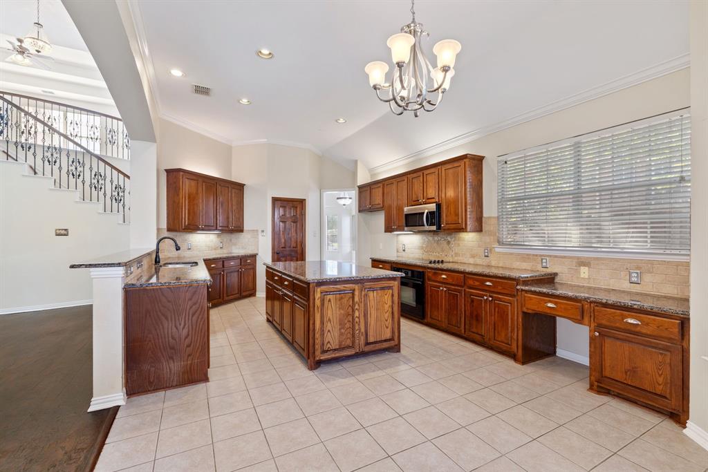 2021 Country Brook Lane Allen, TX 75002 - Photo 14 of 40 a large kitchen with stainless steel appliances granite countertop a large island in the center