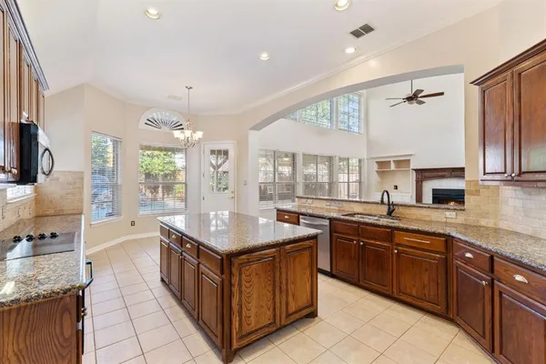 a kitchen with stainless steel appliances granite countertop a stove a sink dishwasher and a refrigerator