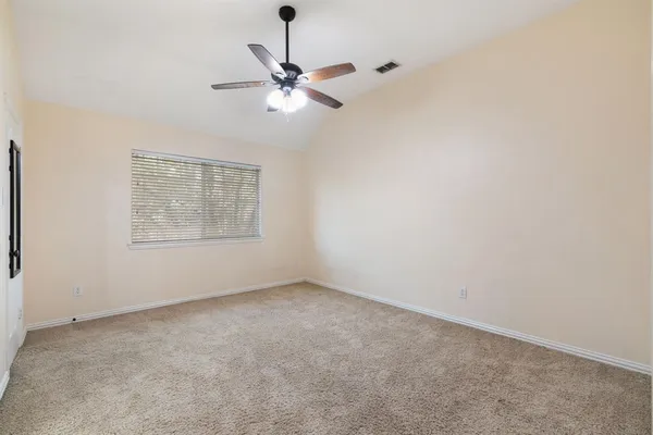 an empty room with a window and a fan