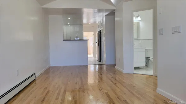 an empty room with wooden floor and entrance