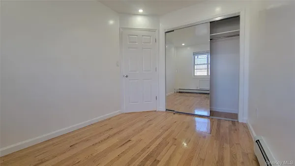 a big room with wooden floor and a bathroom
