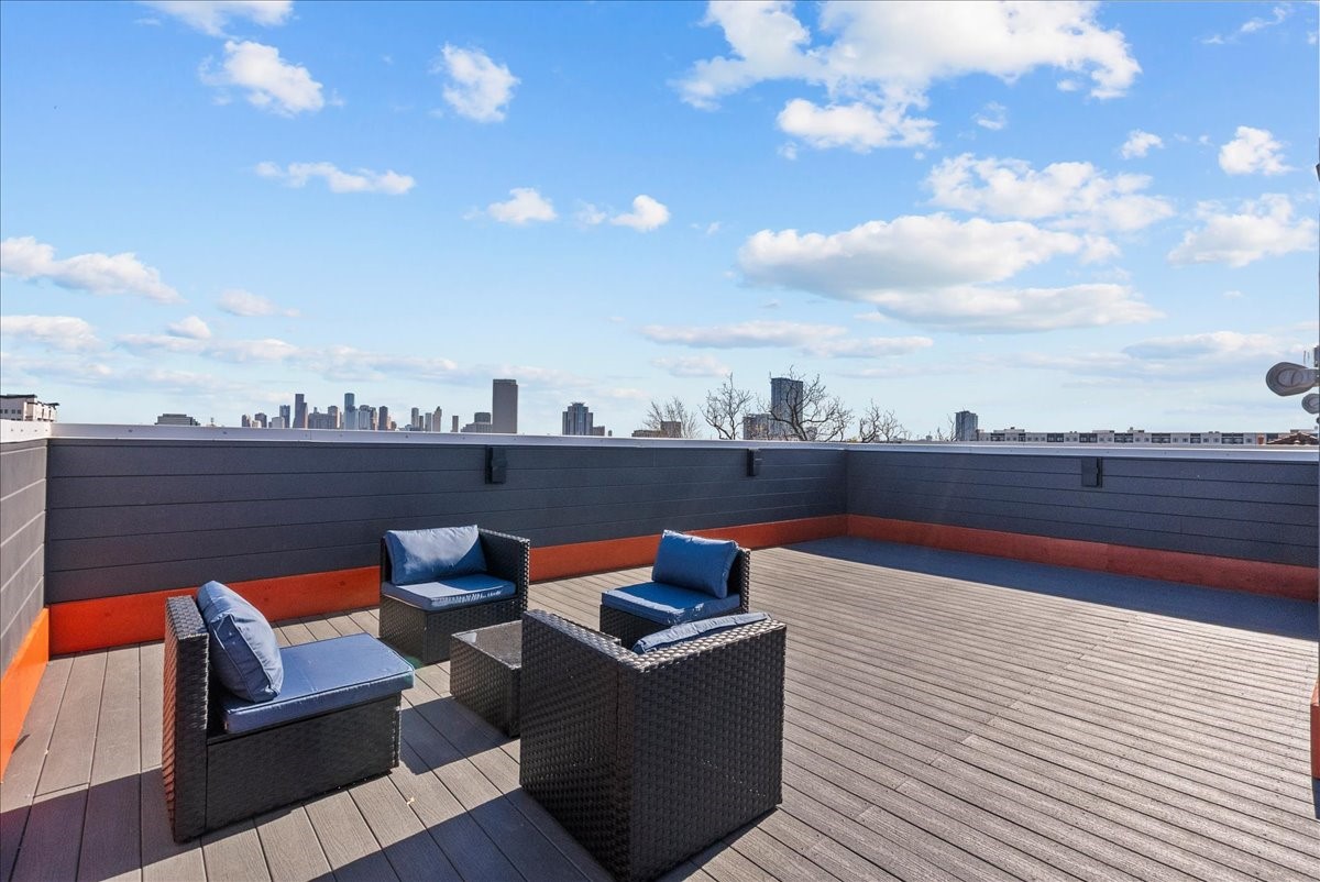 516 Reinerman Street Houston, TX 77007 - Photo 9 of 42 Spacious rooftop deck with modern seating, offering stunning skyline views under a clear blue sky. Ideal for relaxing or entertaining.