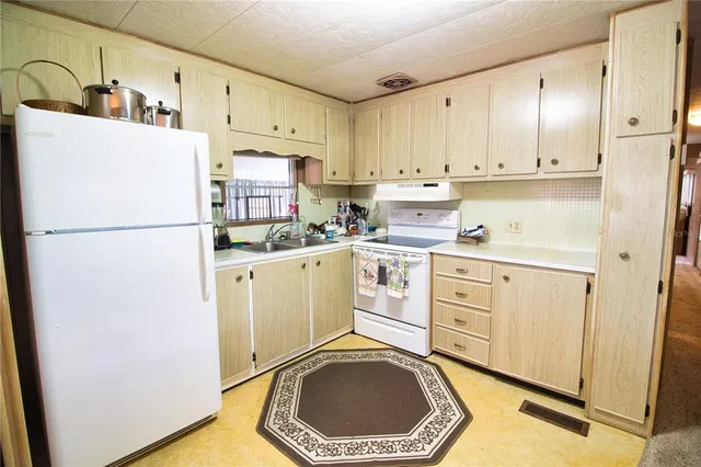 a kitchen with a refrigerator sink stove and cabinets