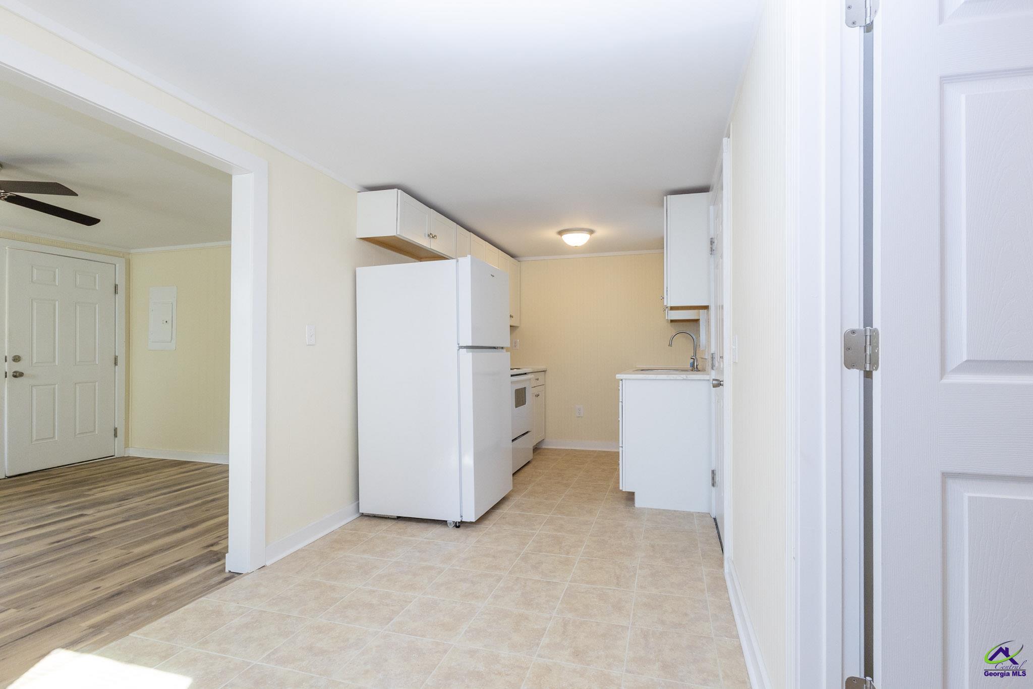 156 Churchwell Road Cochran, GA 31014 - Photo 9 of 20 a view of a kitchen with white cabinets and wooden floor
