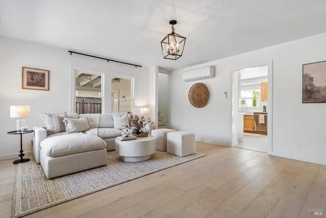 a living room with furniture a chandelier and a window