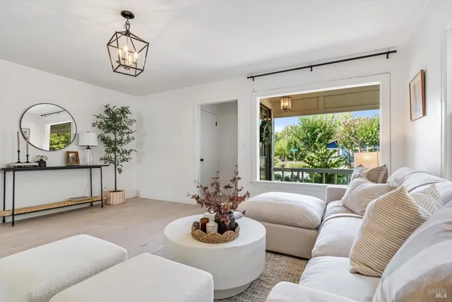 a living room with furniture a chandelier and a window