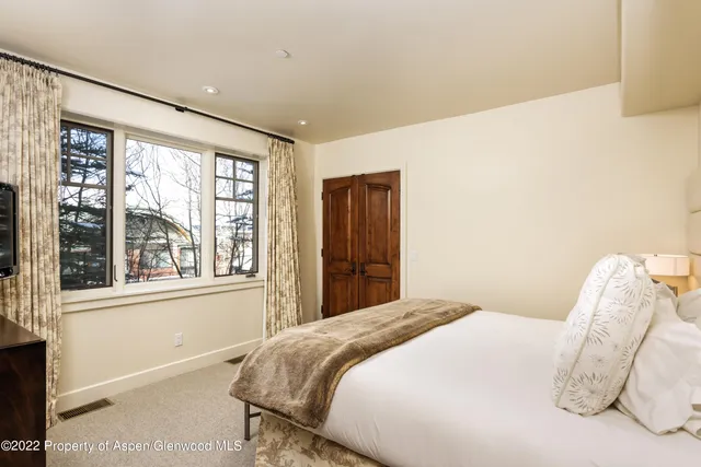 a bedroom with a bed and a large window