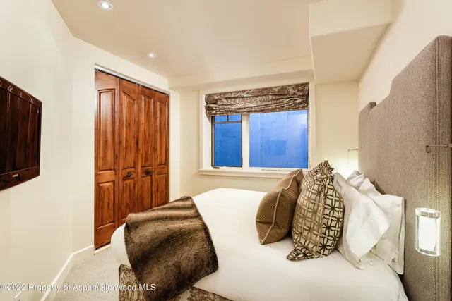 a bedroom with a large bed and a flat screen tv