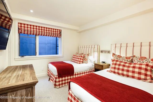 a bedroom with two beds and painting on the wall