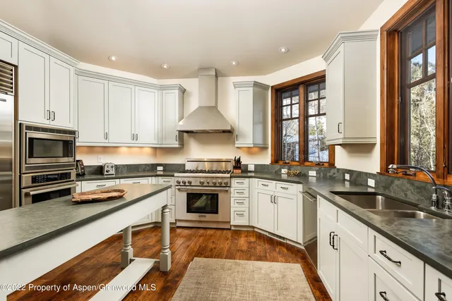 a kitchen with stainless steel appliances granite countertop a stove sink and cabinets