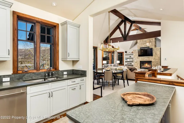 a kitchen with stainless steel appliances granite countertop a sink a stove and a wooden cabinets