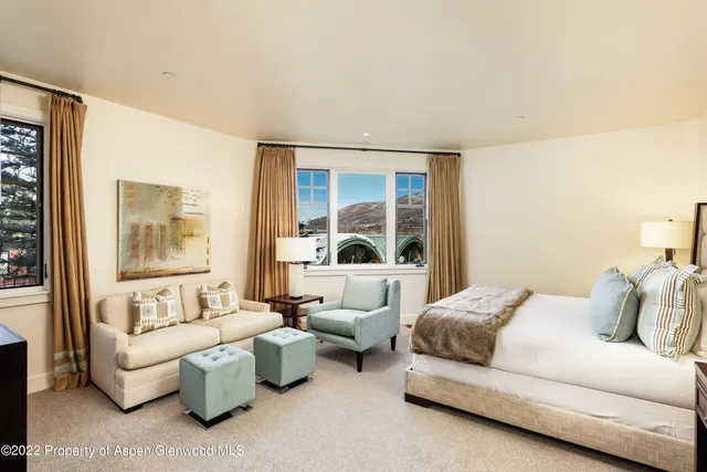 a bedroom with furniture and a large window