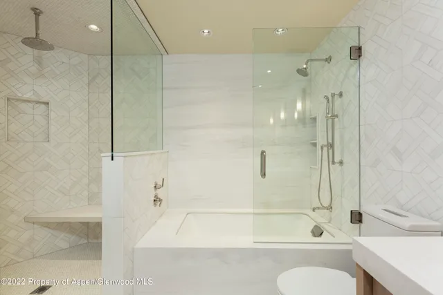 a bathroom with a bathtub shower sink and toilet