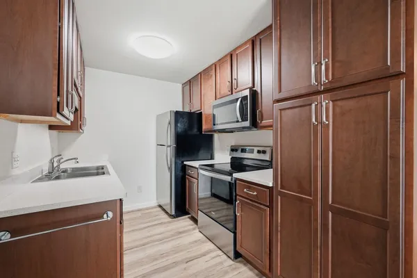 a kitchen with stainless steel appliances granite countertop a refrigerator stove and sink
