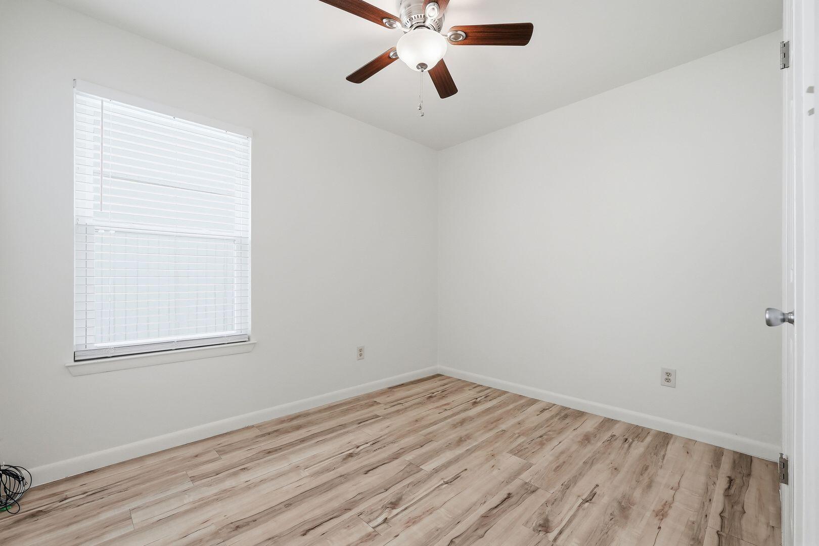 5 Kelly Way Valparaiso, FL 32580 - Photo 17 of 31 an empty room with wooden floor chandelier fan and windows