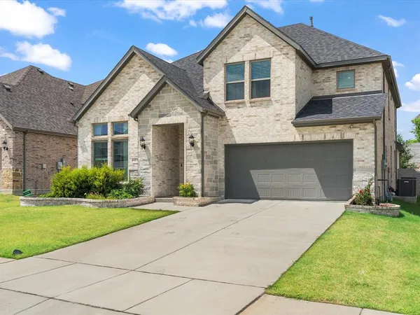 a front view of a house with a yard and garage