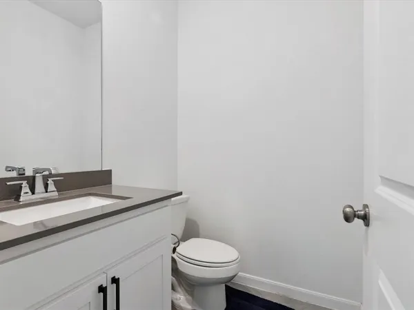 a bathroom with a granite countertop toilet and a sink