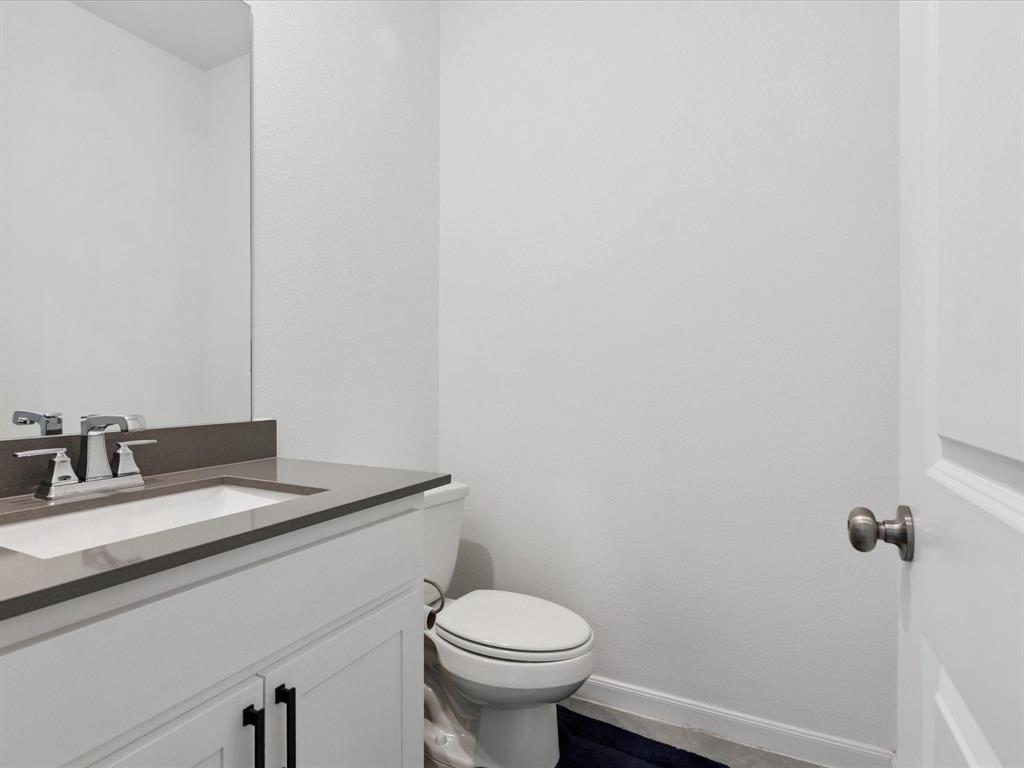 4828 Celestial Road McKinney, TX 75071 - Photo 21 of 25 a bathroom with a granite countertop toilet and a sink
