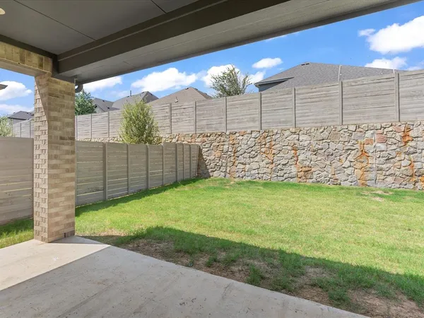 a view of a yard with wooden fence