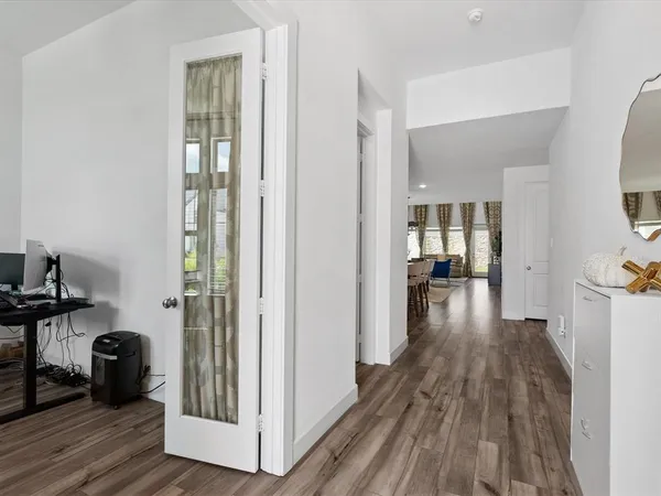 a view of a hallway with wooden floor and a living room