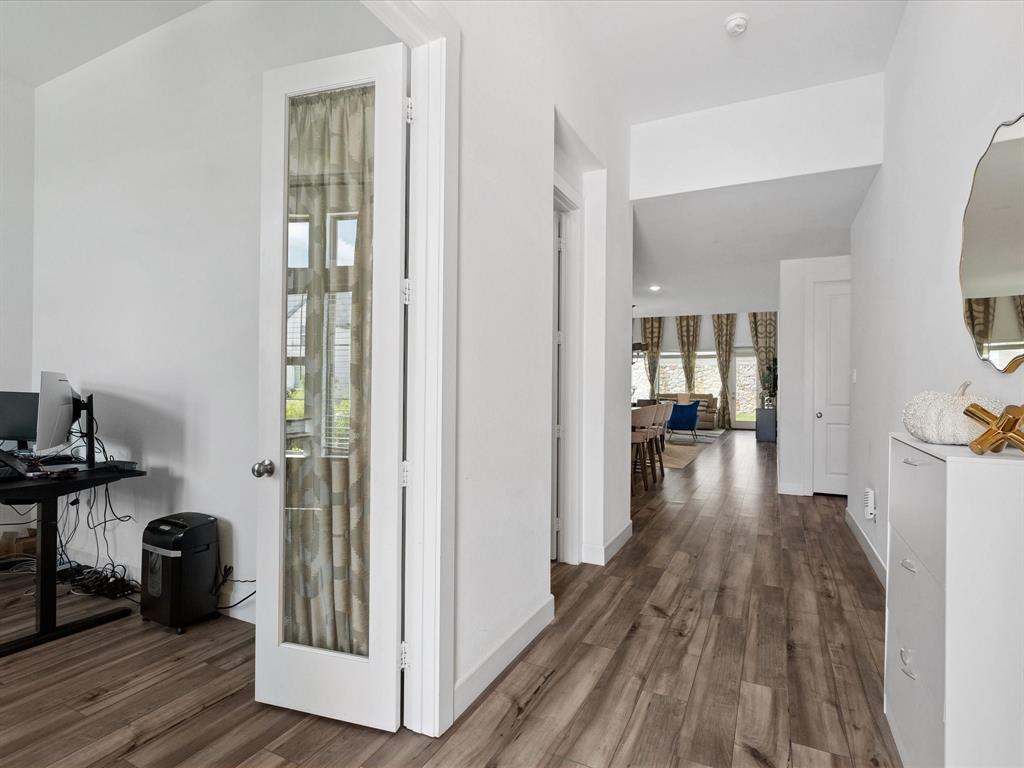 4828 Celestial Road McKinney, TX 75071 - Photo 4 of 25 a view of a hallway with wooden floor and a living room