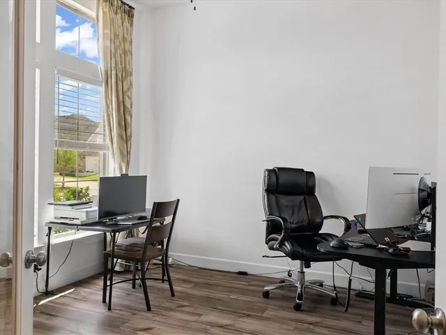 a view of a workspace with furniture and a window