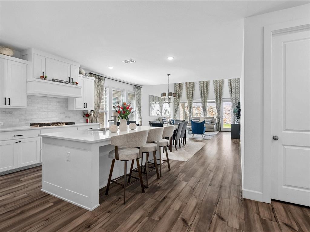 4828 Celestial Road McKinney, TX 75071 - Photo 6 of 25 a kitchen with a table chairs refrigerator and cabinets
