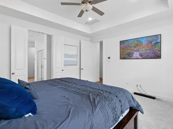 a bedroom with a bed and a ceiling fan