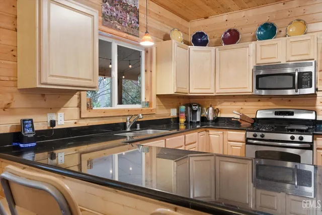 a large kitchen with stainless steel appliances granite countertop a stove and a sink