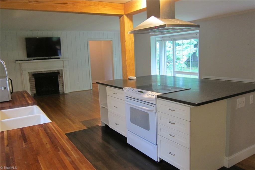 2419 Oak Ridge Road Oak Ridge, NC 27310 - Photo 5 of 30 Kitchen opens to Den...wood floors...solid surface counter top on island...wood beams.