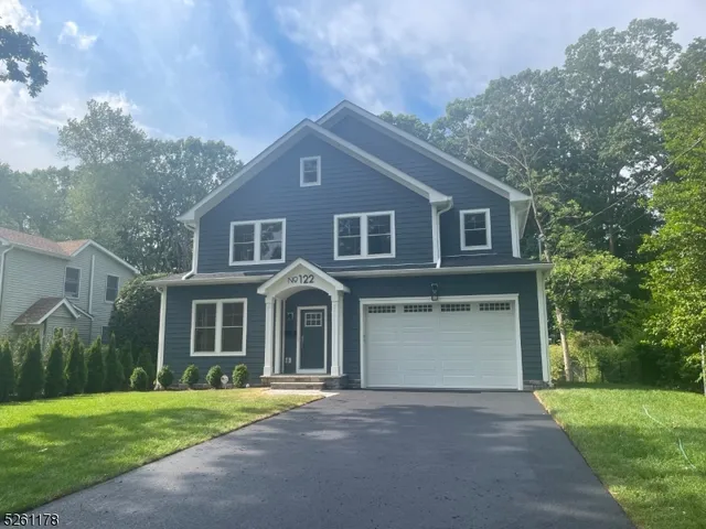 a front view of a house with a garden and yard